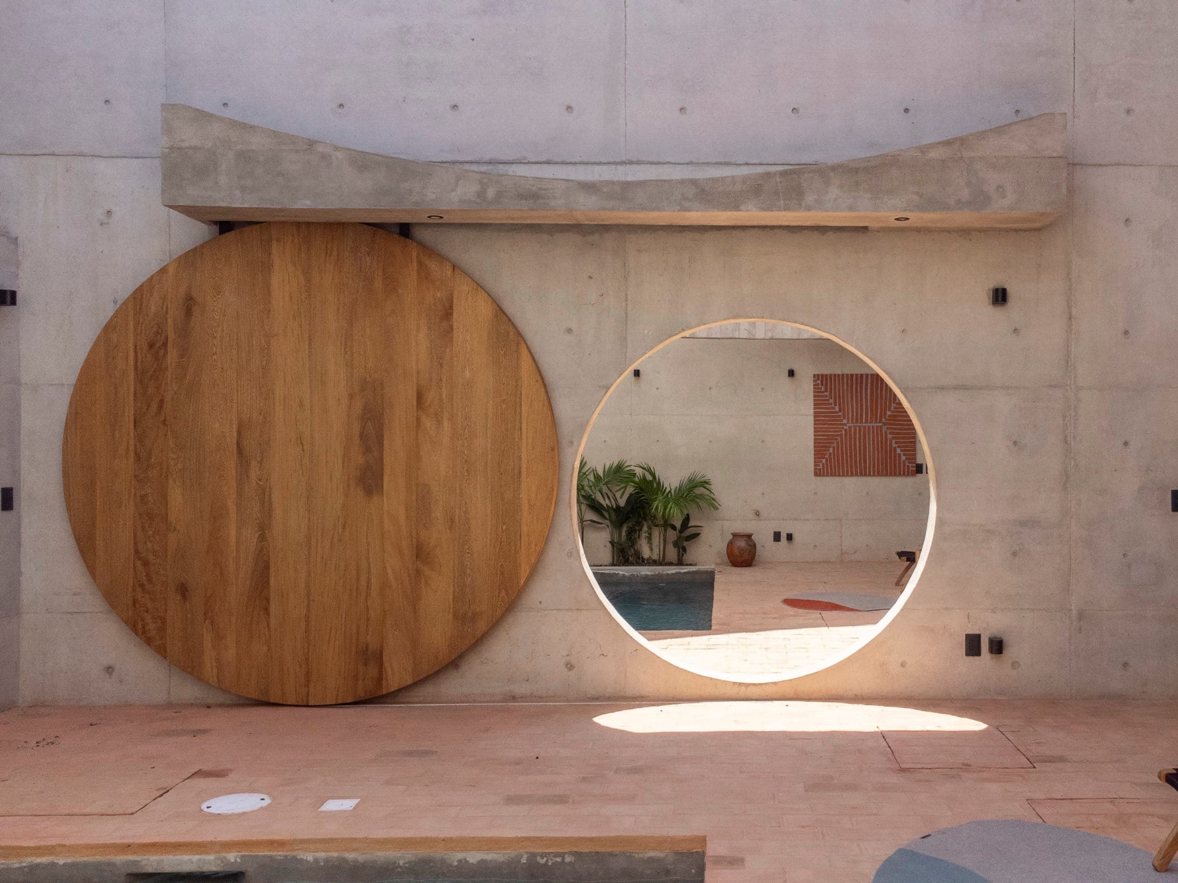 Casa Campeche, fachada de concreto con puerta circular de madera